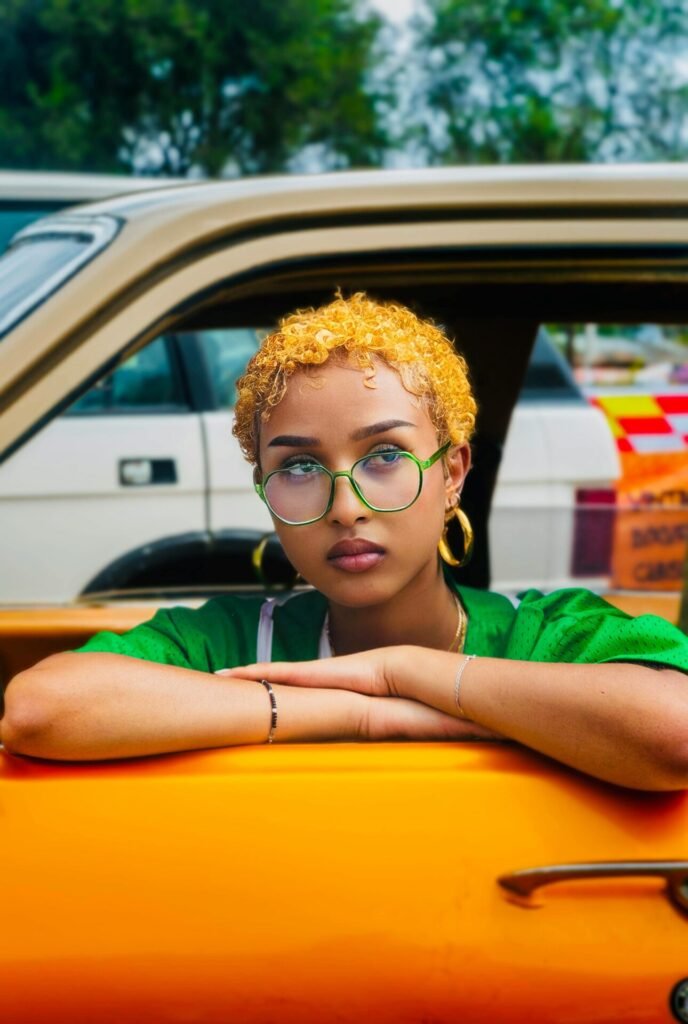 Photo by Abiy Fikru: https://www.pexels.com/photo/a-woman-with-dyed-orange-hair-sitting-in-an-orange-car-26583625/